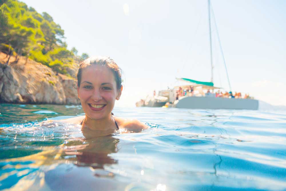 Swimming in front of a catamaran cruise boat