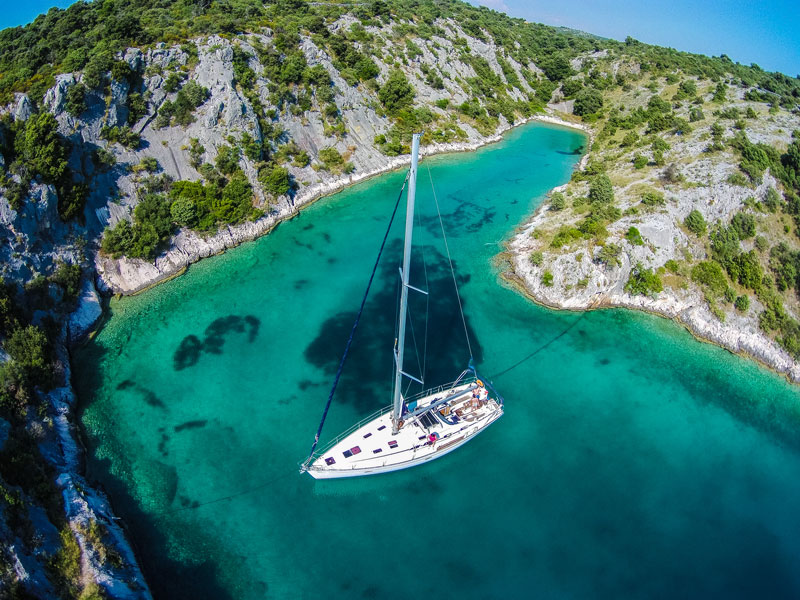 Sailing yacht on anchor in a crystal clear bay